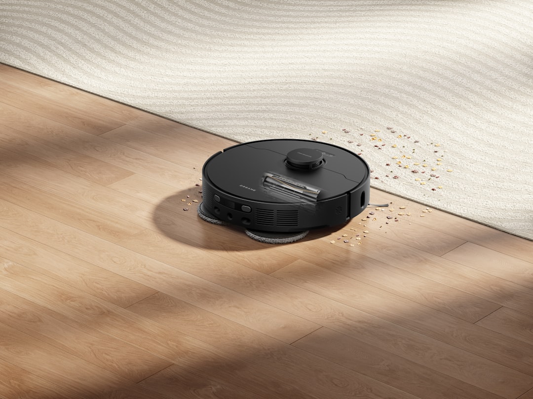 about-01 Dreame black robot mop and vacuum cleaner is removing debris on a wooden floor, combining power and elegant design.